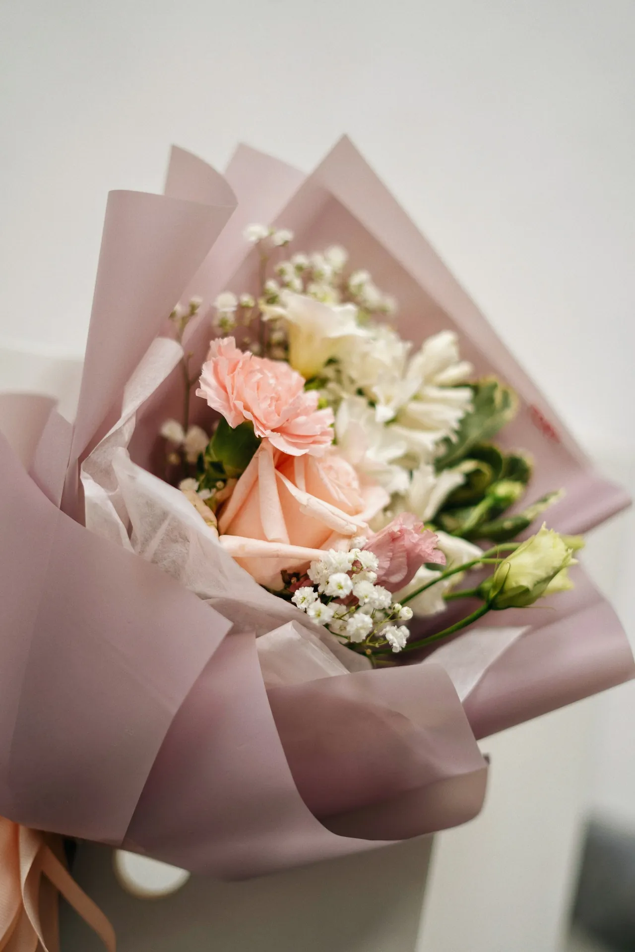 Buket mawar dan bunga pastel dalam bungkus kertas pink